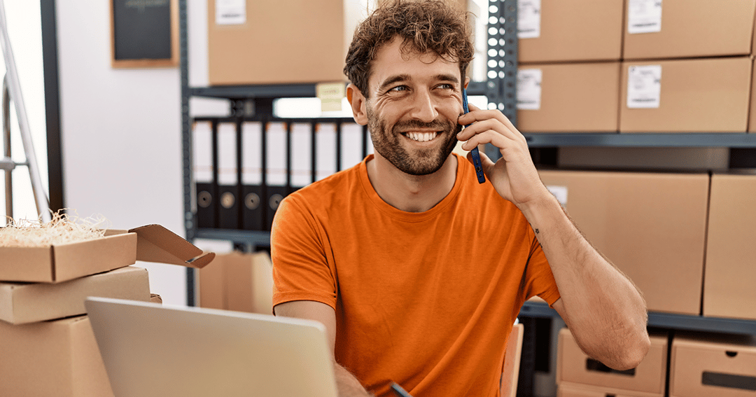 man-in-office-warehouse-with-parcels-on-the-phone