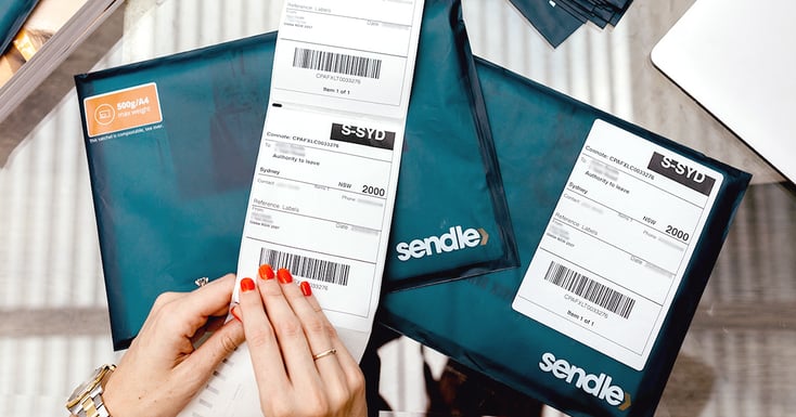 hand-preparing-shipping-label-over-stack-satchels-500-grams-email-banner-sendle-australia