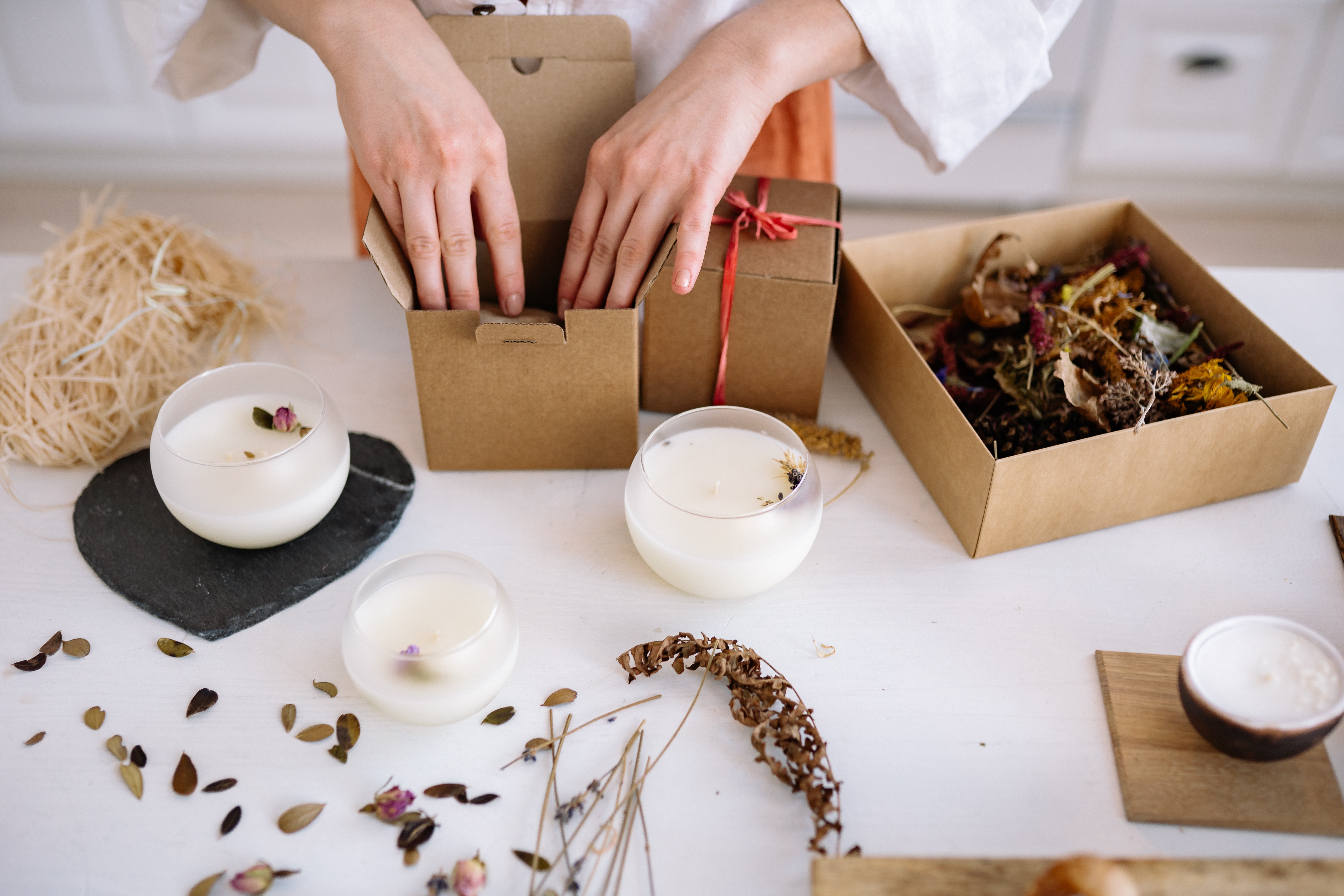 A Person Packing Candles on Cardboard Boxes