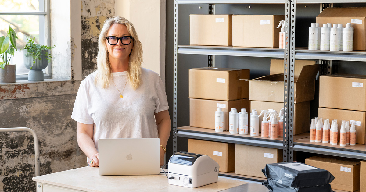 non products founder jacqui afflick behind laptop table preparing shipping satchels