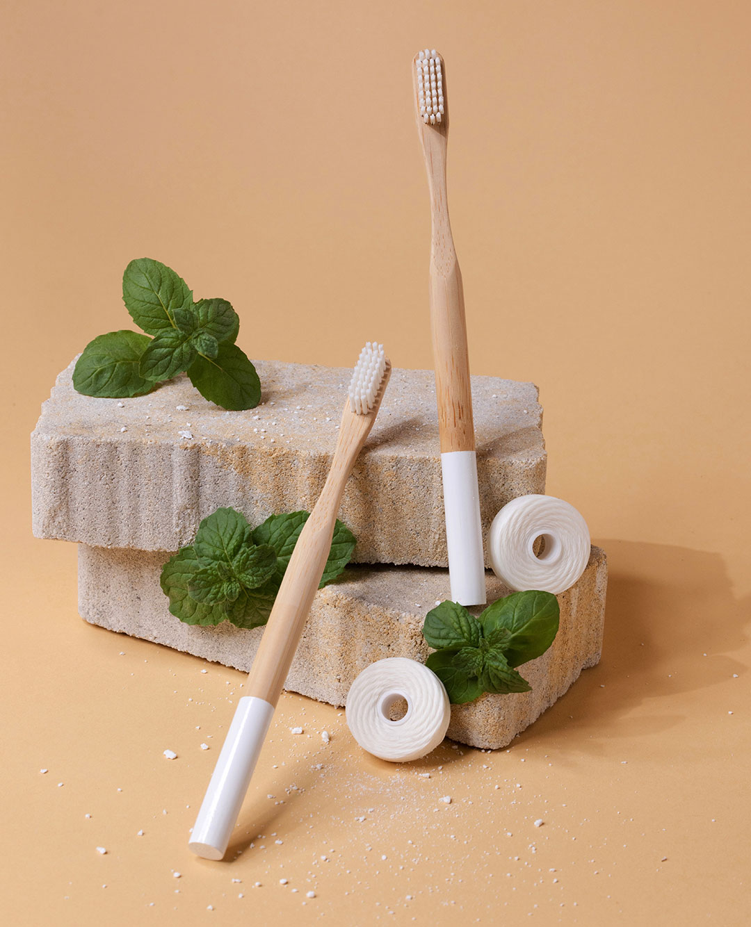 Two sets of bamboo toothbrush on a decorative stone