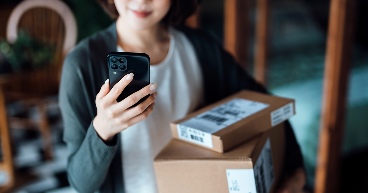 woman holding phone and packages