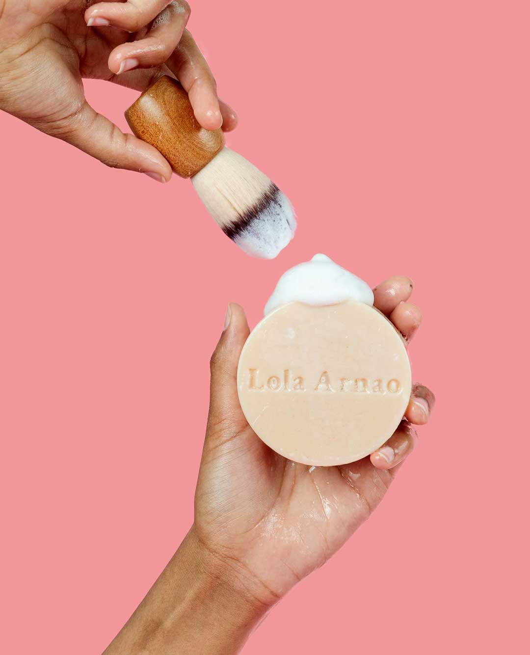 person holding a bar of soap and brush from lola arnao