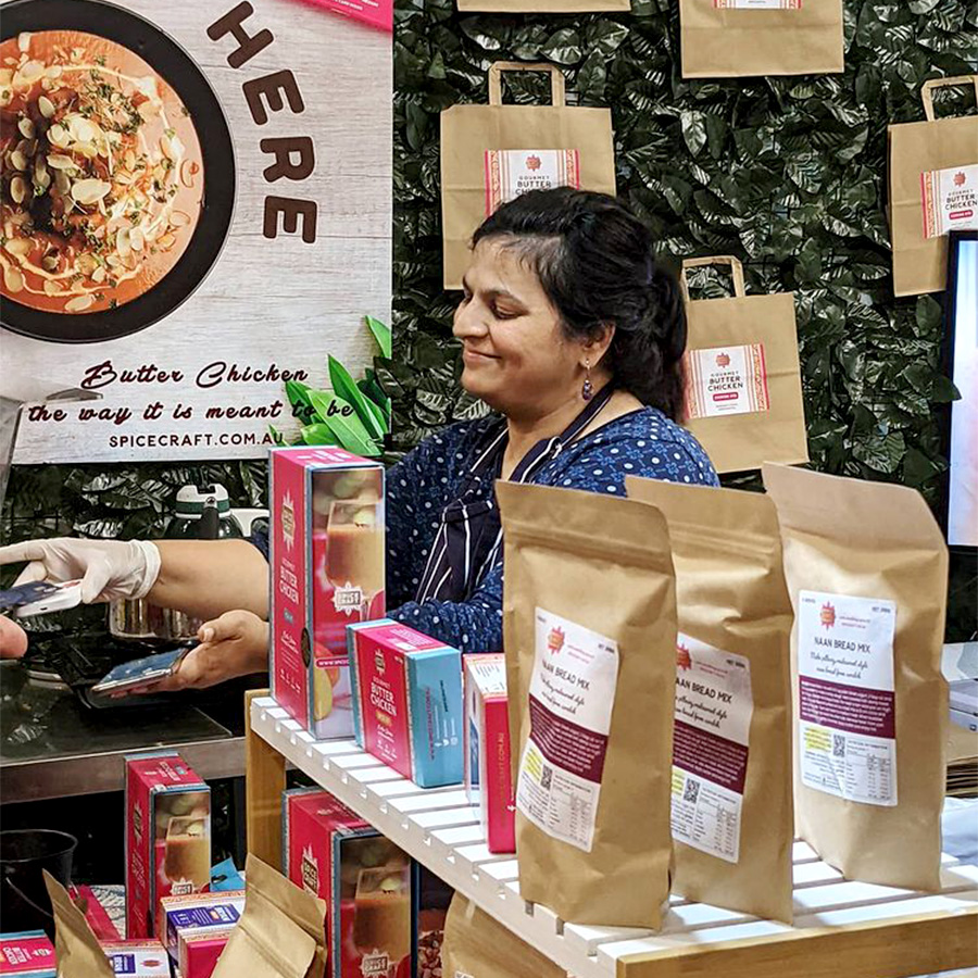 spicecraft founder ambika malvia in shop stall engaged in a transaction with a customer
