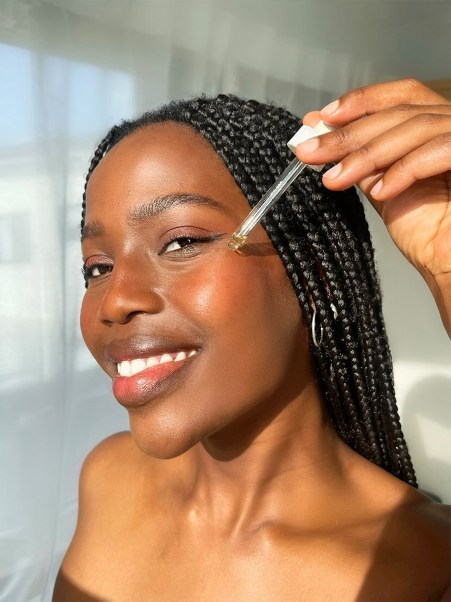 close-up-on-face-black-woman-using-skin-care-serum-on-cheeks