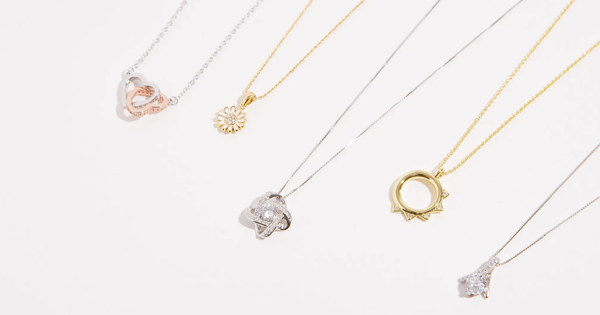 gold and silver necklaces lined up with white background