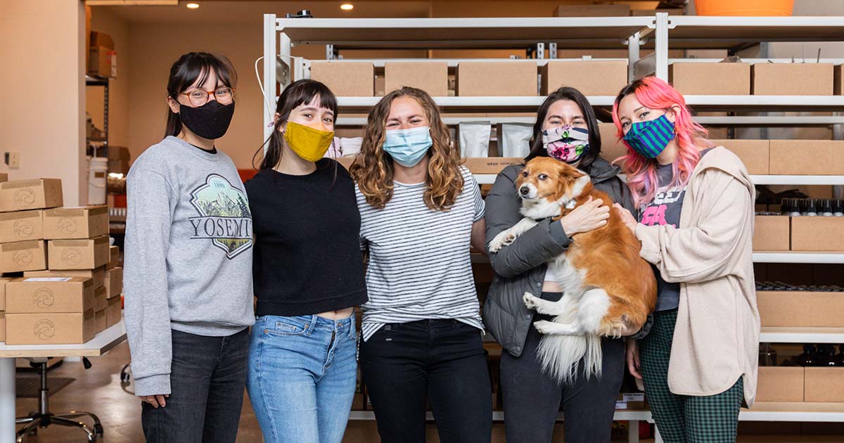 five female close together wearing medical face masks posing for the camera