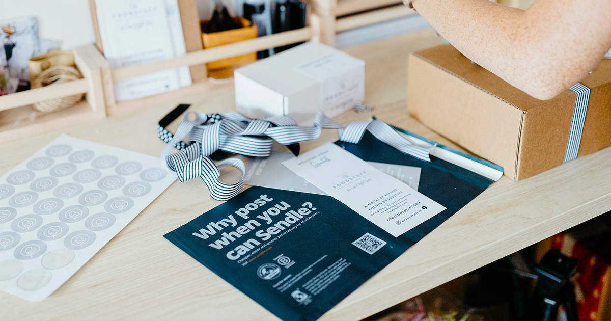 person wrapping a parcel using sendle compostable satchel