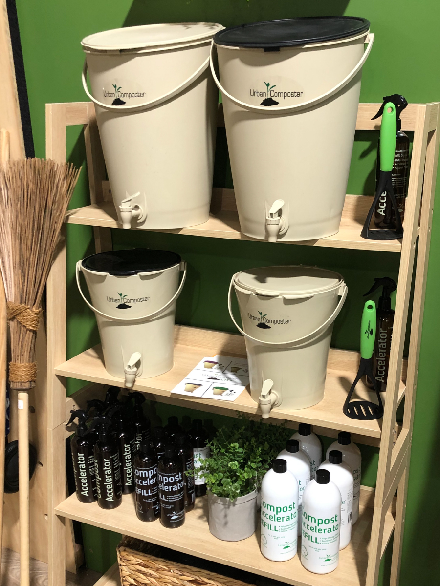 shelf full of Urban Composter bins and other products