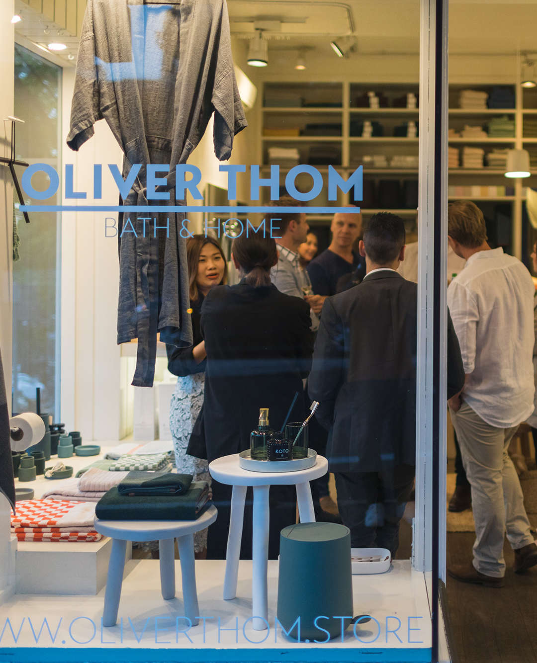 a crowd of people inside a shop, view from outside glass window