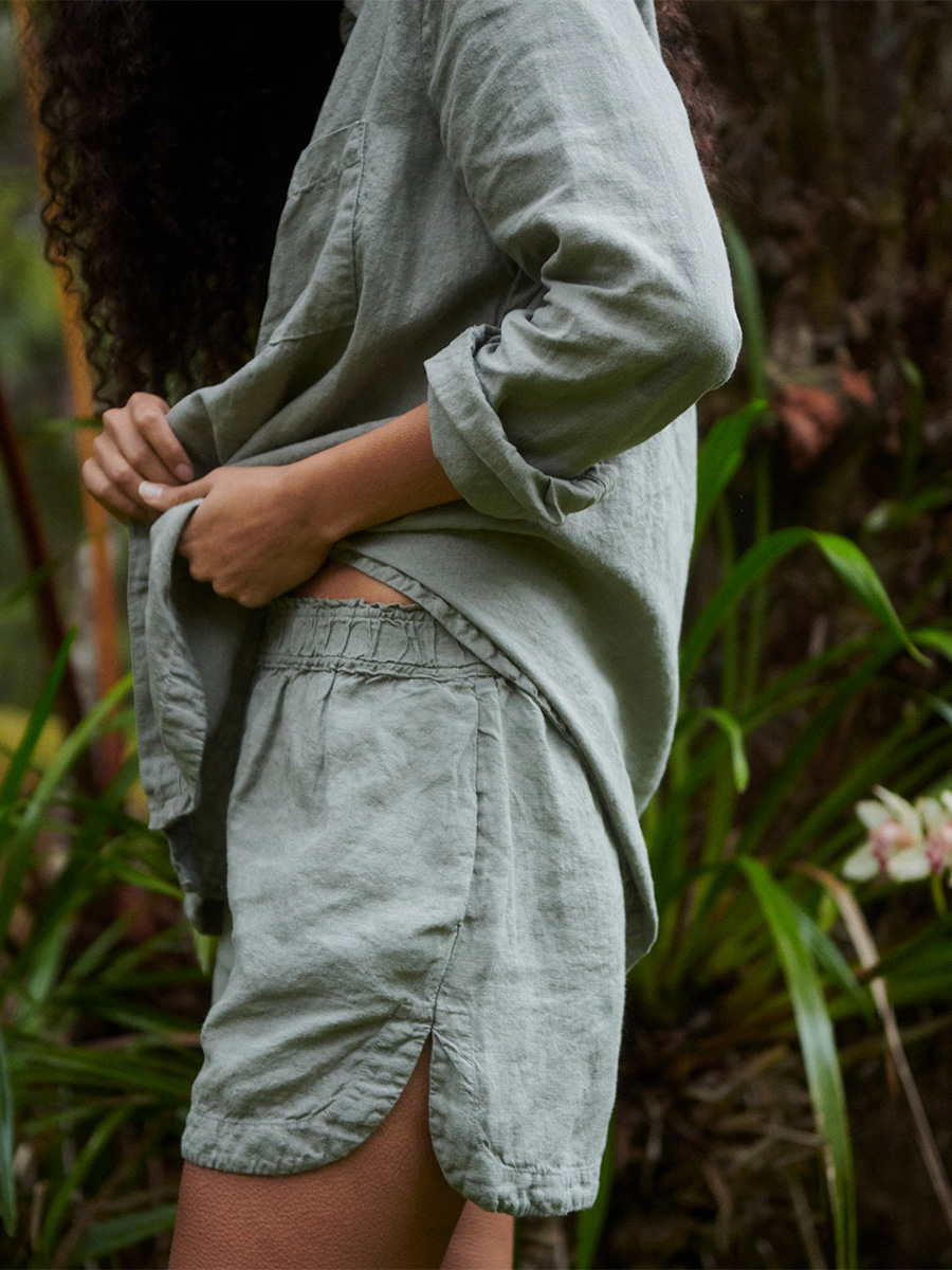 pali swim linen tops and bottoms worn by a woman standing in front of plants