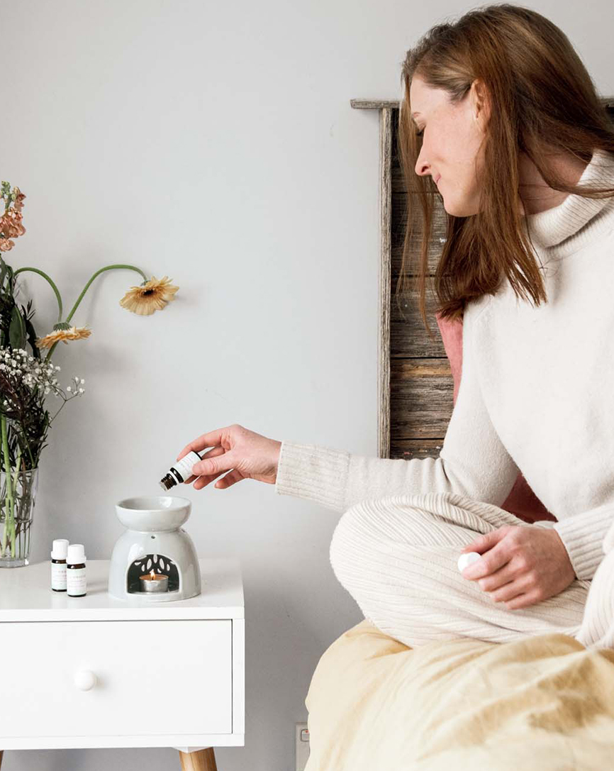 person using burner with essential oil in bed