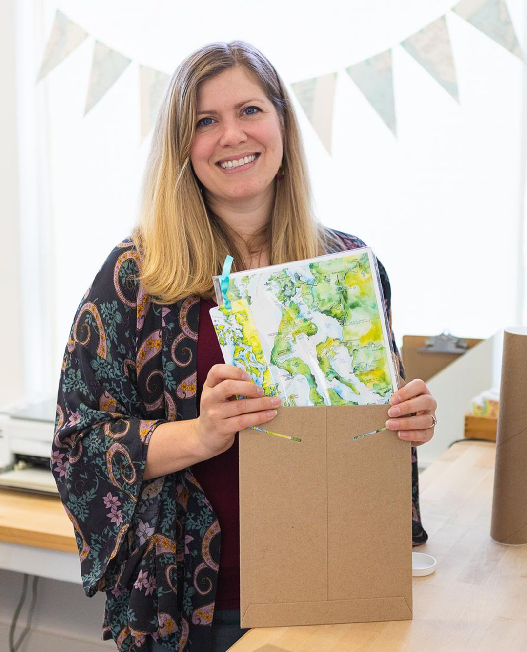 blonde woman putting art print in brown envelope