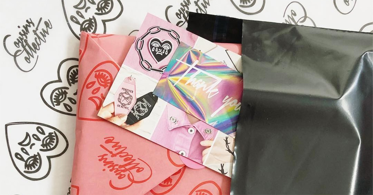 package wrapped in paper with heart illustrations and cards inside a shipping parcel by cousins collective