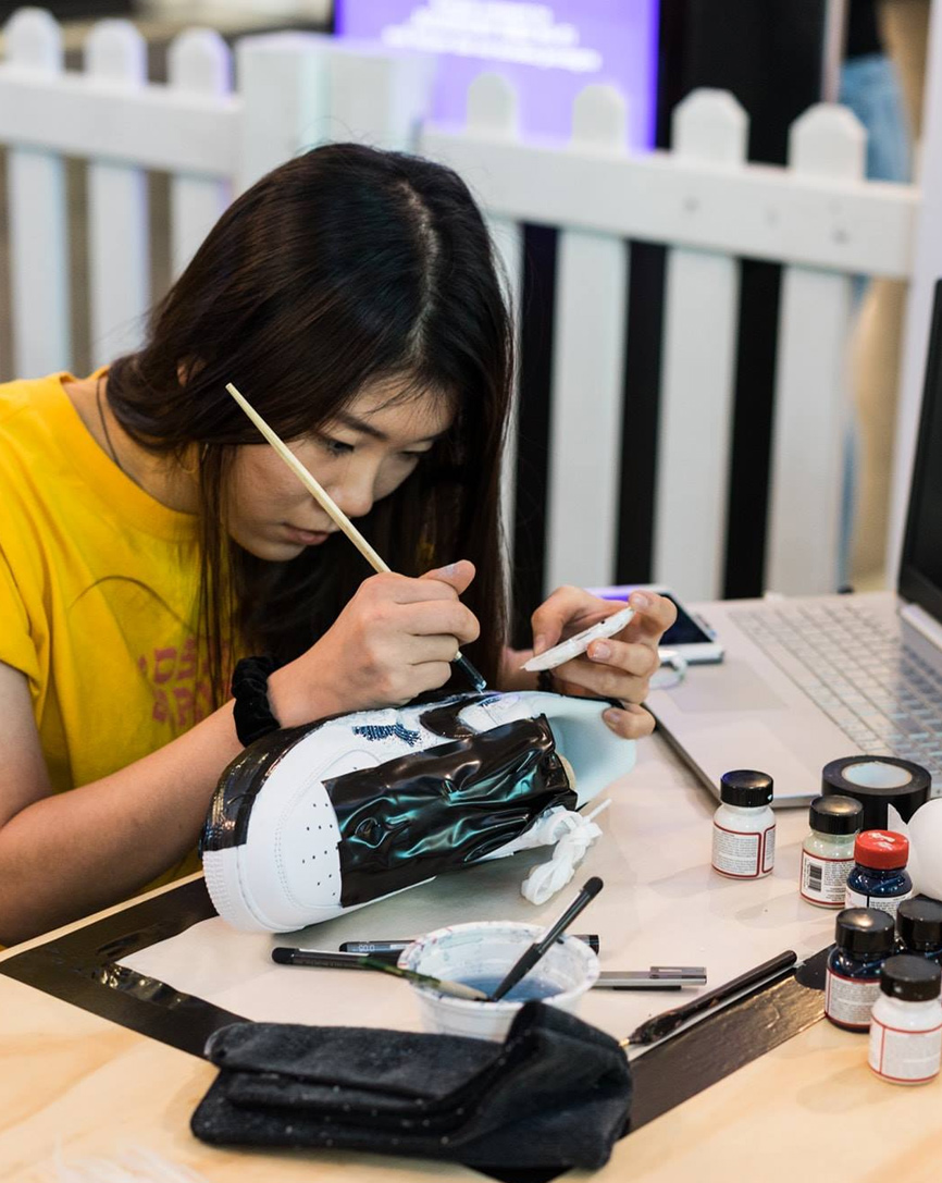 person restoring shoes with paints