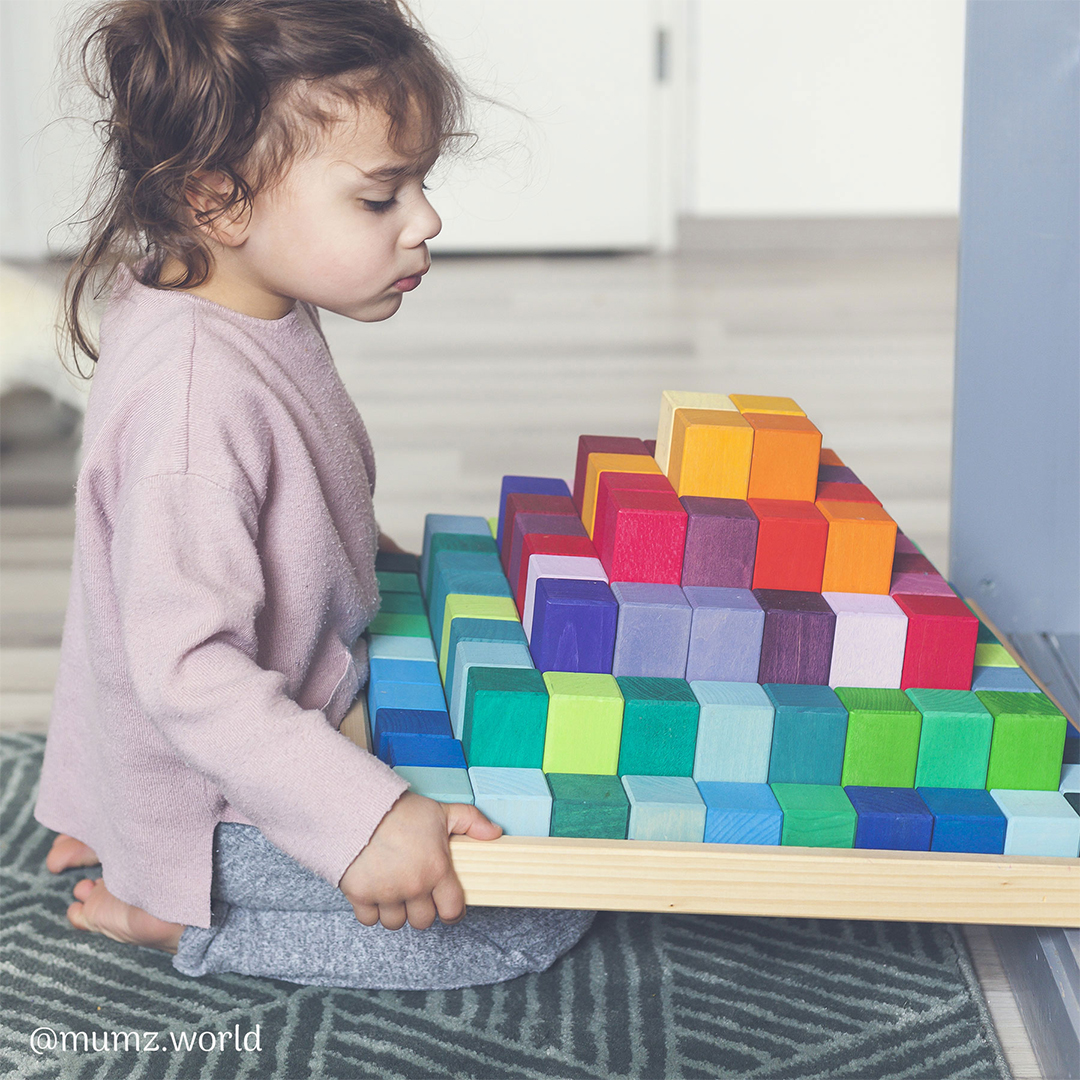 child playing with colorful wooden blocks
